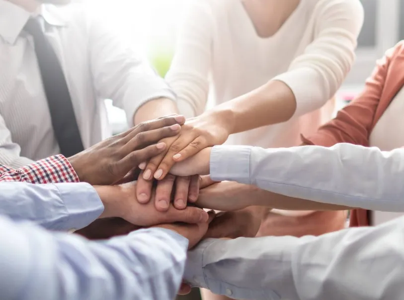 Team members placing hands together in collaboration