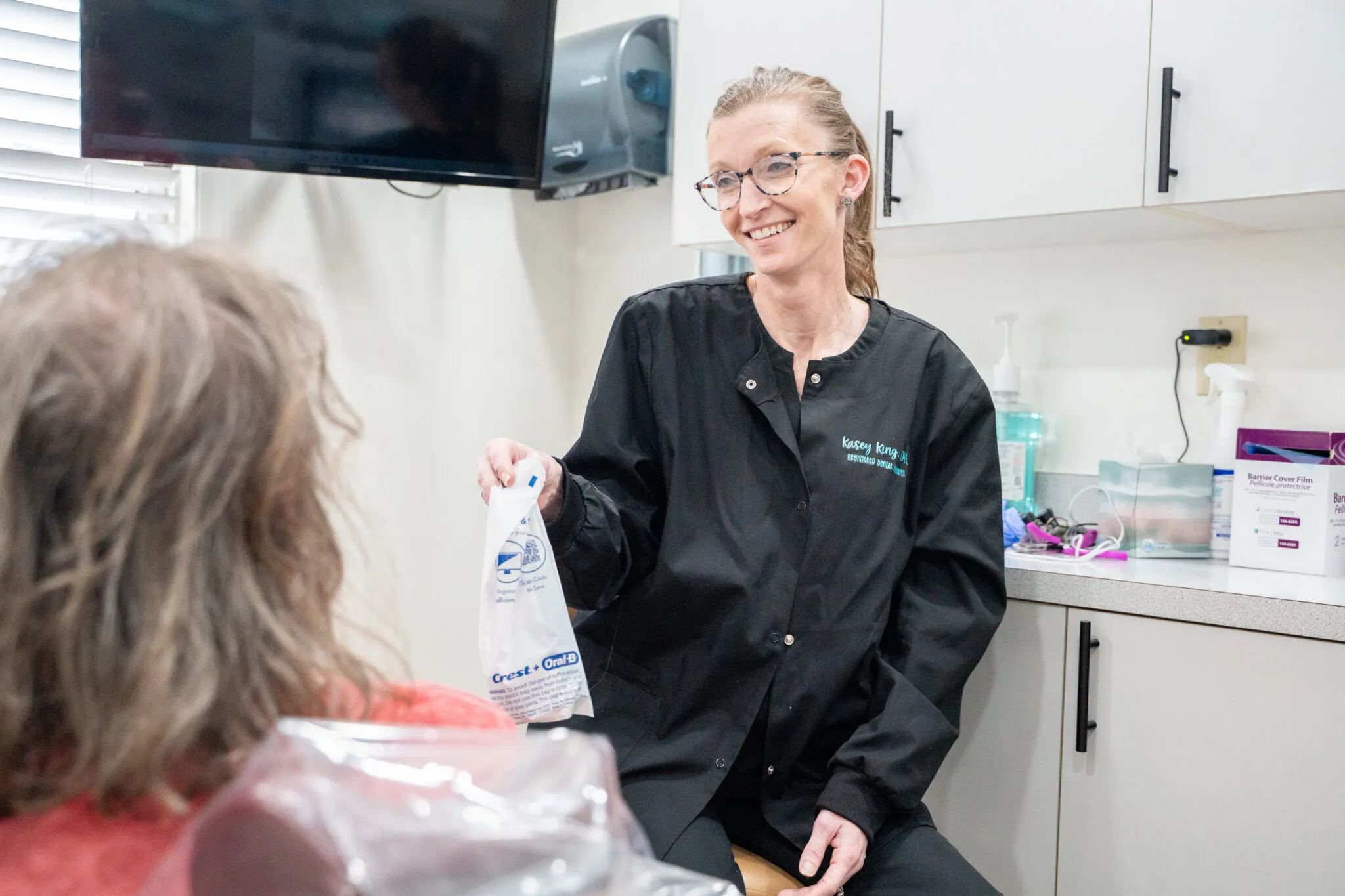 Friendly dental staff member with a patient in the treatment room