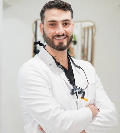Dr. Shaikh smiling in a white coat