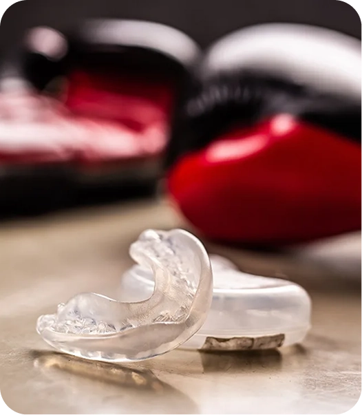 Clear custom-fitted athletic mouthguard resting on a light surface