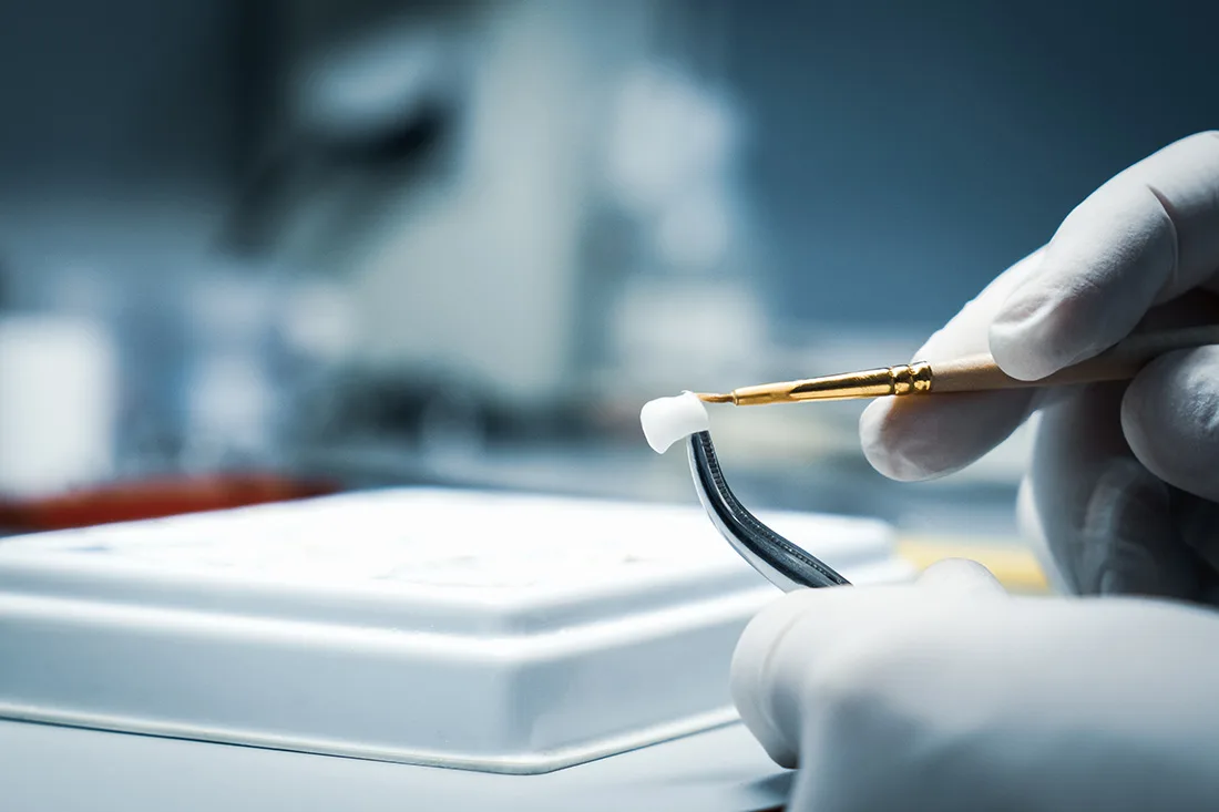 Dental technician refining a same-day crown in the lab